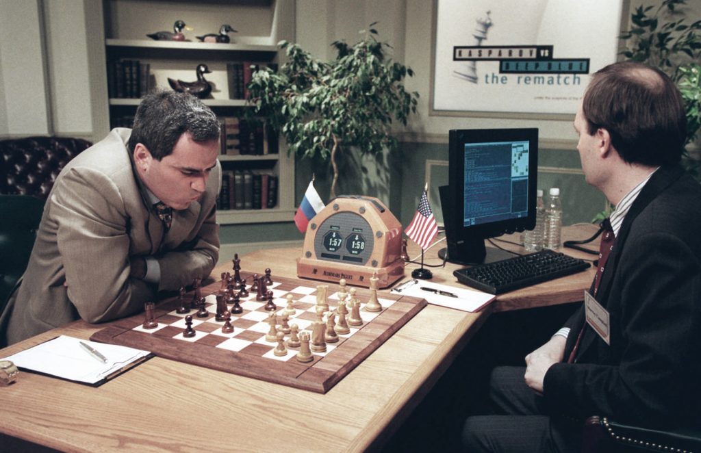 Garry Kasparov, left, is contemplating his next move against Deep Blue, IBM's chess playing computer Sunday, May 4, 1997, in New York, during game two of their six-game rematch. It was Man 1, Machine 0, as world chess champion Kasparov won the first game of his rematch on Saturday. Deep Blue can examine an average of 200 million positions per second. The man at right is unidentified. 