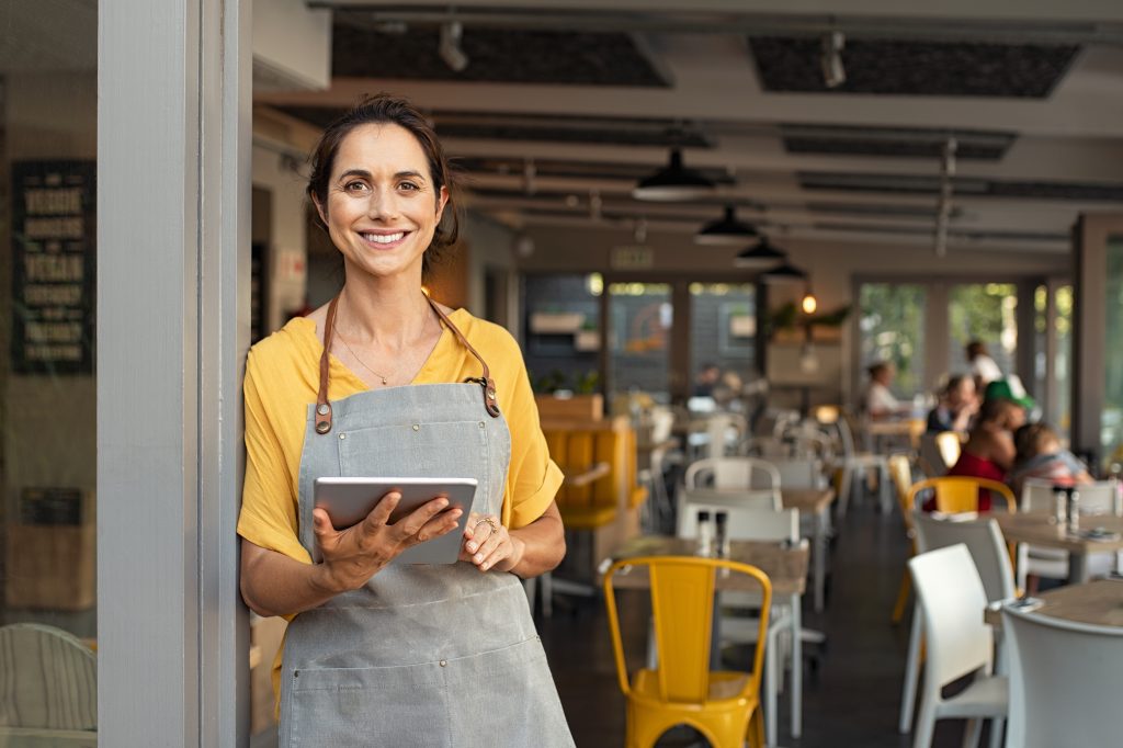 Small business team using cloud VDI cloud desktops on laptops in modern office, illustrating affordable remote work solution.